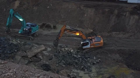 Excavators working in mud on construction site at dusk Stock Footage 334528366