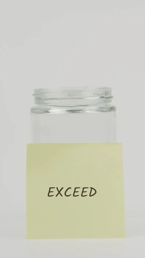 Exceed text or word on yellow sticky note attached to glass jar with hand Stock Footage 311728522