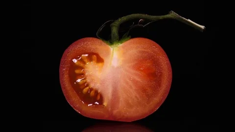 Excellent close up of slit red tomato with stem, rotating on black background Stock Footage 74947139