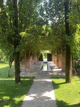 An excellent landscape solution includes an artificial pond and a pergola with Stock Photos