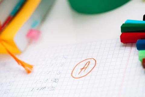 Excellent score next to the correct solution on a piece of paper in front o.. Stockfoto's