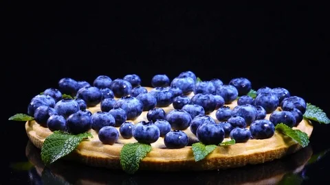 Excellent side-view of round pie with fresh blueberries and mint leaves Video stock 77716013