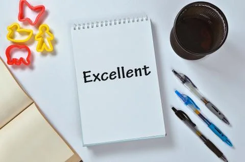 Excellent text on notepad with office accessories. Business motivation, inspi Stock Photos
