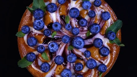 Excellent top-view of round pie with fresh blueberries and mint leaves Stock-Footage 78352179