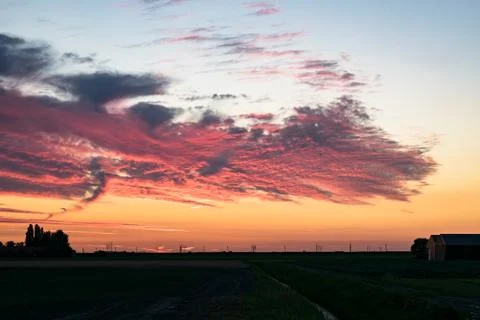 Exceptional beautiful red clouds over the dutch countryside at sunset. Stock Photos