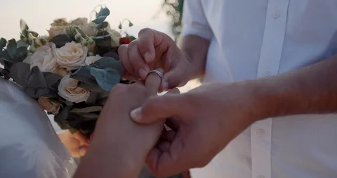 Exchange of rings at a wedding ceremony, close up hands of the bride and groom Stock Footage 123782602