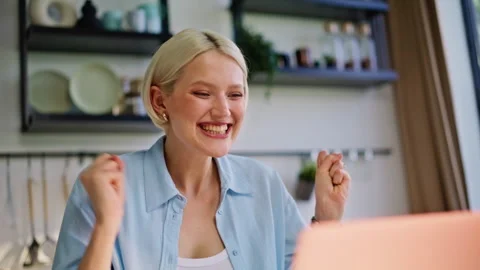 Excited blonde looking computer screen celebrating success at kitchen closeup Stock Footage 335152965