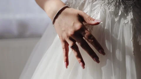 Excited bride touching and caressing her white wonderful wedding dress. Close up Stock Footage 134881424