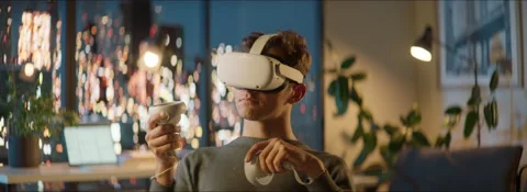 Excited Caucasian man using his VR virtual reality metaverse headset at home Stock Footage 209470027