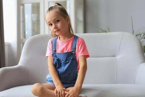 Excited child looking at camera while sitting in living room at home. Stock Photos