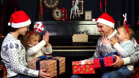 Excited children clapping hands opening up surprise gift box wrapped Christmas Stock Footage 98690639