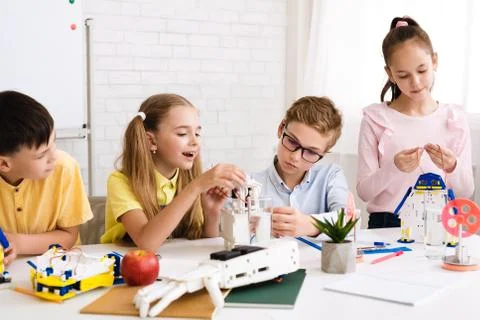 Excited children programming robots together at stem class Stock Photos