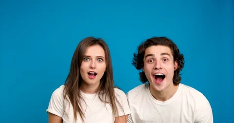 Excited couple looking at camera, smiling, holding hands and embracing isolated Stock Footage 124536124