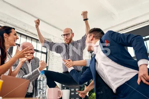 Excited diverse business team employees screaming celebrating good news business Stock Photos