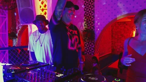 Excited DJ raising hands while performing a live music set in a nightclub Stock Footage 337886159