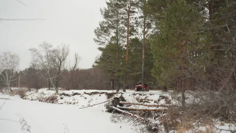 Excited driver on red ATV crosses icy marshy terrain in winter. Fastmoving ATV Stock Footage 332046541