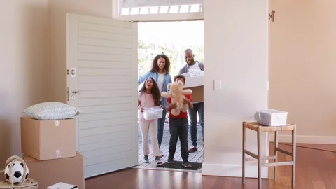 Excited Family Carrying Boxes Into New Home On Moving Day Stock Footage