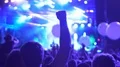 Excited fans jumping and applauding at concert, big balloons flying above crowd HD Footage