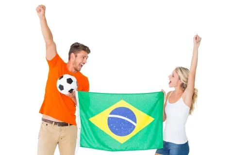 Excited football fan couple holding brazil flag Stock Photos