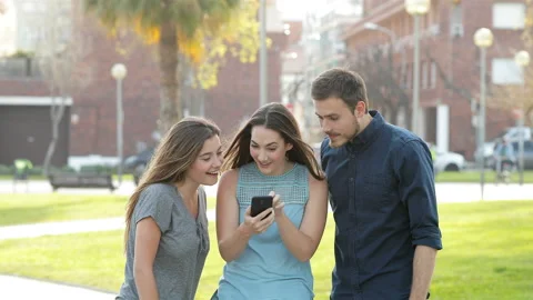 Excited friends jumping after checking phone content Stock Footage 106863004
