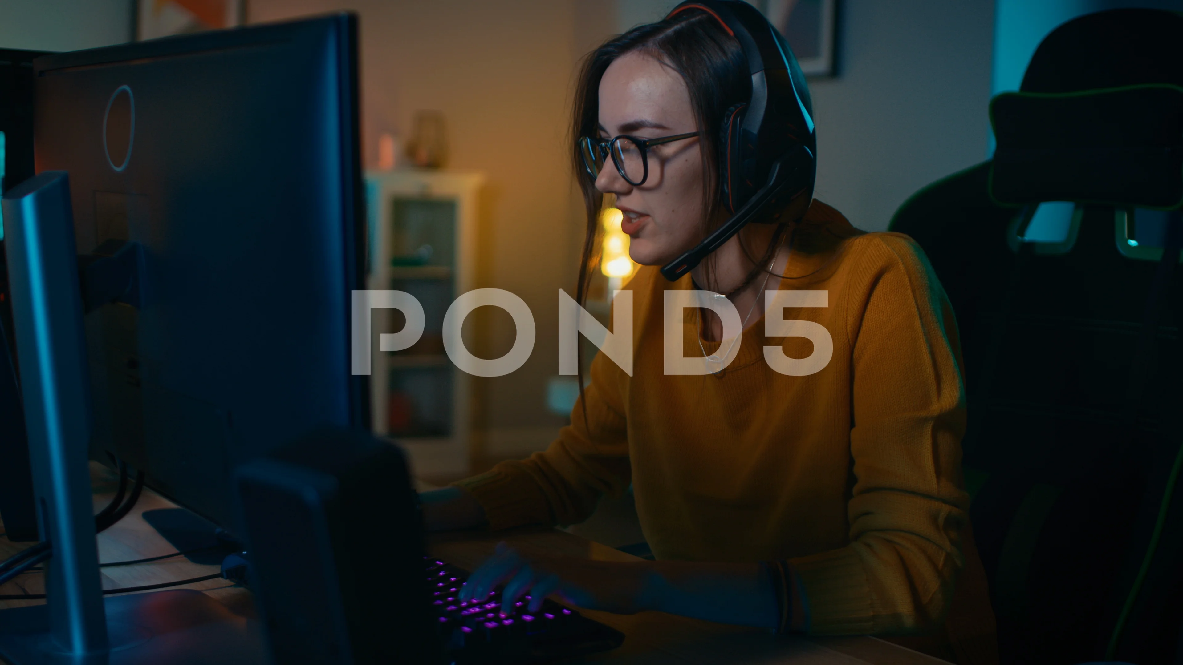 Excited Gamer Girl in Headset with a Mic Playing Online Video Game on Her PC