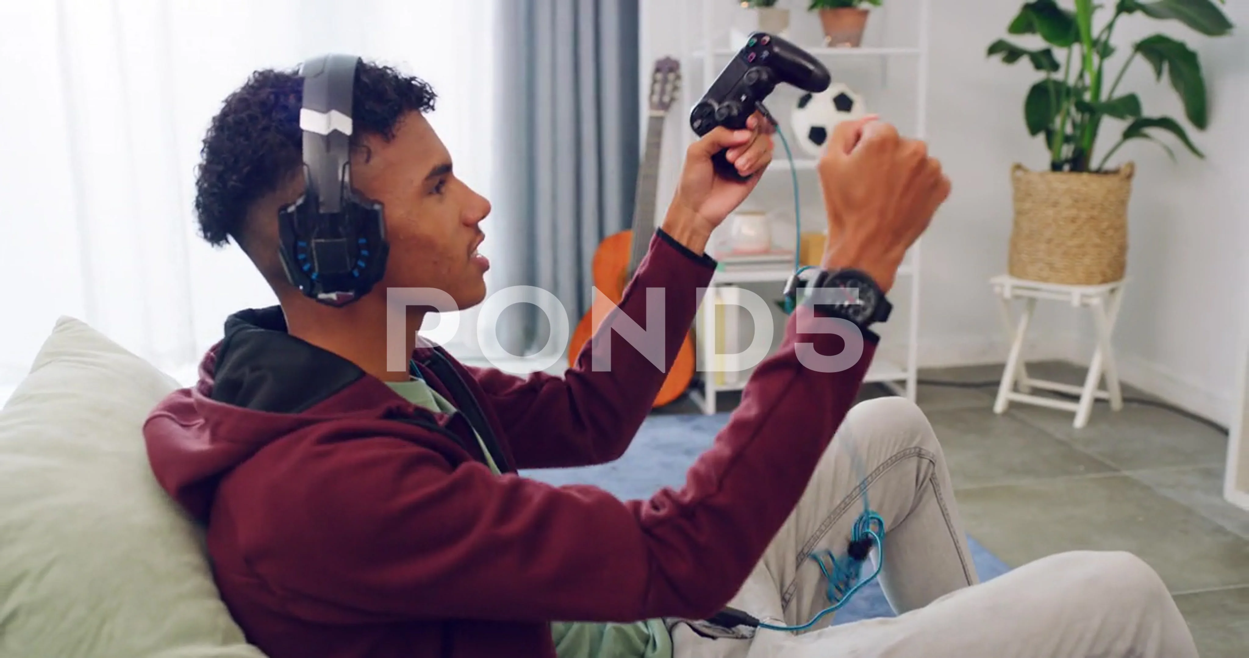 An excited gamer is sitting on a couch, playing a video game on a console.  He