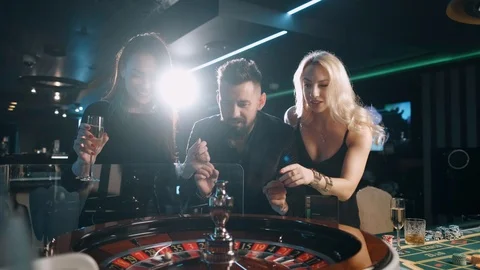 Excited group of bearded man and two beauty woman are winning at casino roulette Stock Footage