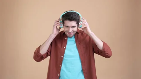 Excited guy listen headset rock melody dance isolated patel color background Stock Footage 169939070