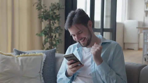 Excited Man Celebrating Success While Looking At Smartphone Screen Stock Footage 318930634