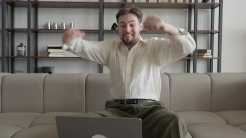 Excited Man Celebrating Success While Watching Laptop At Home Sofa 스톡 동영상 331791758