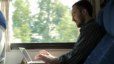 Excited man checking work on a tablet in the train being satisfied about the Stock Footage 115974994
