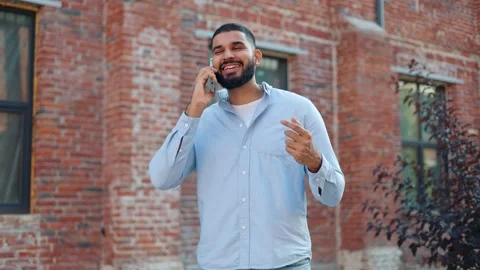 Excited man gesturing hand during conversation with friend on mobile phone Video stock 250387728
