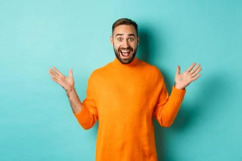 Excited man react to promo offer, spread hands sideways and rejoicing, standing Stock Photos