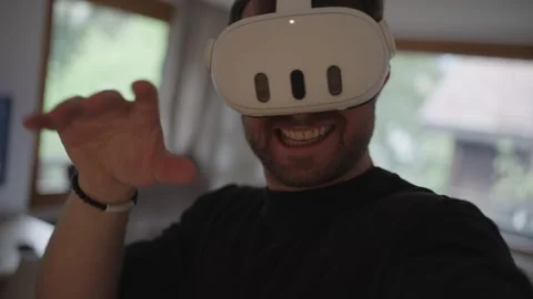 Excited man using a vr headset, interacting with his hands in a virtual reality Stock Footage 335469799