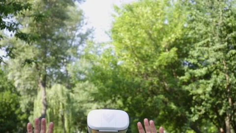Excited man in vr headset gesturing in park Stock-Footage 136114902
