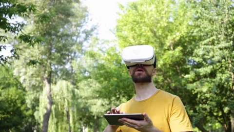 Excited man in vr headset using digital tablet in park Stock-Footage 136114474