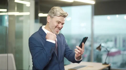 Excited mature business man hold smartphone overjoyed businessman ceo executive  Stock Footage