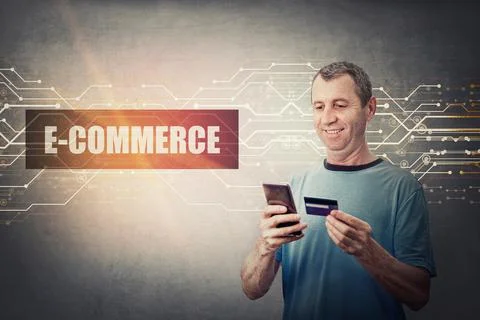 Excited middle aged man using a smartphone while holds his credit card, brows Stock Photos