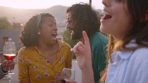 Excited multiracial group of friends dancing and singing at sunset on rooftop Stock Footage 244596738