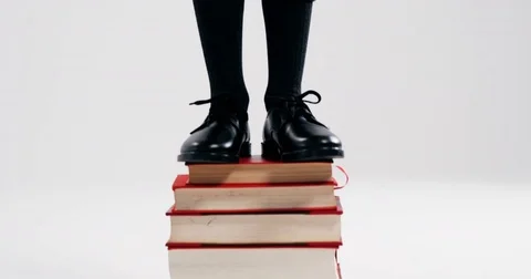 Excited schoolboy standing on stack of books Stock Footage 78882627