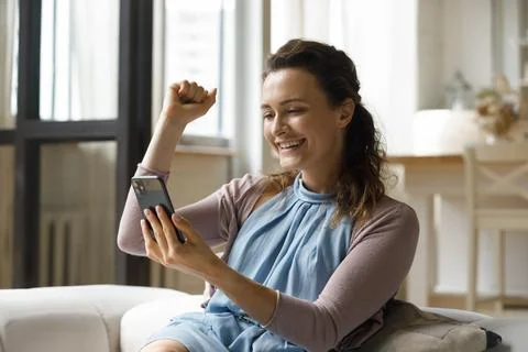 Excited smartphone user reading text message on digital gadget screen Stock Photos