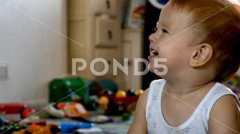 Excited smiling baby boy siting on floor at home and watching tv Stock Photos