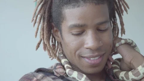 Excited smiling man in dreadlocks and checkerboard pattern shirt with two col Stock-Footage 126054385