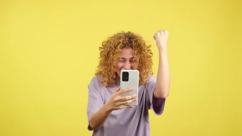 Excited woman celebrating while using the mobile phone Stock Footage 234112724
