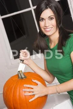Excited woman cutting carving halloween pumpkin jack-o-lantern Stock Photos
