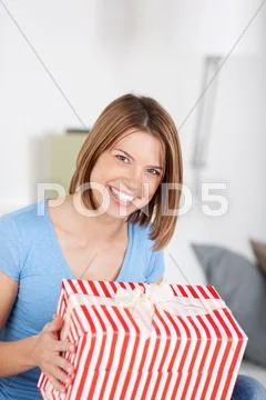 Excited woman with a large striped gift Stock Photos