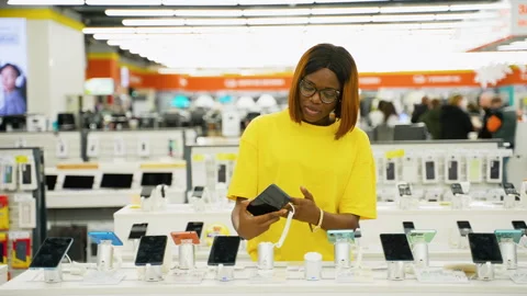Excited woman testing smartphone in electronics store Video stock 301733257