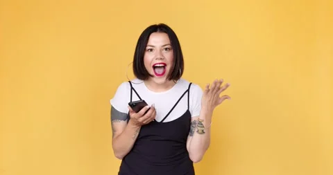 Excited woman using smart phone checking good news, surprise  win game app Stock Footage 136553653
