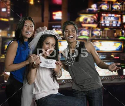 Excited Women Holding Gaming Voucher In Casino