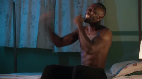 Excited young African man using his smartphone on his bed at night. and jubilate Video stock 345755582